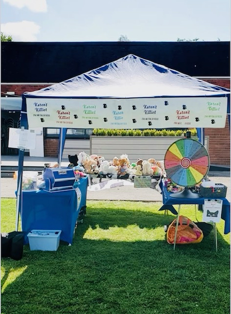An image of a stall at a fundraising event, with a spin wheel and prizes